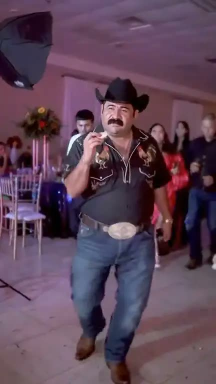 A man in a cowboy hat and a rooster shirt dances into the quinceañera: an AI version posted on TikTok by @elmariobrox